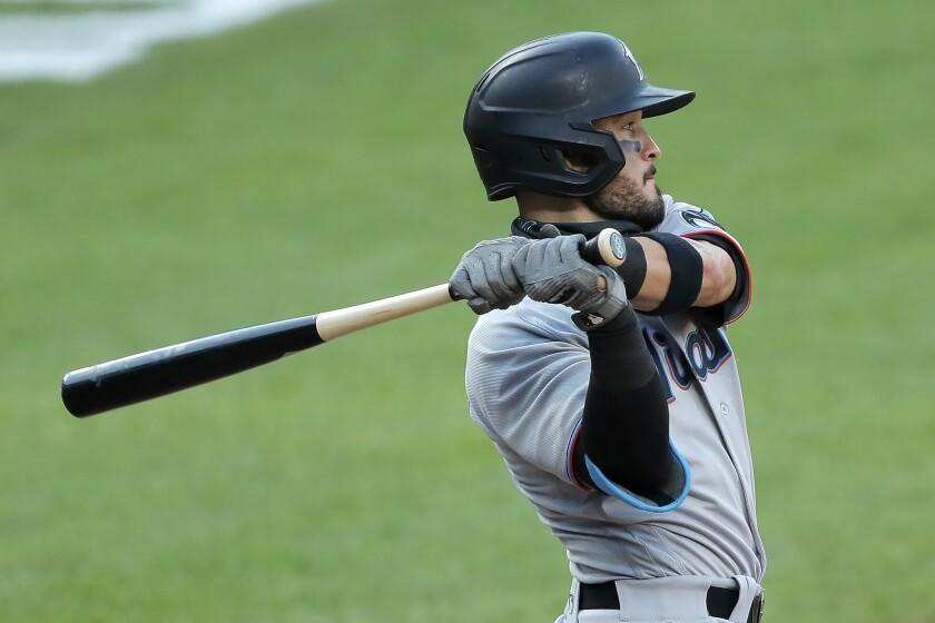 The Olympic rings are seen on the knob of Miami Marlins' Eddy Alvarez's bat as he swings at a pitch from the Baltimore Orioles during the seventh inning in the first game of a baseball doubleheader, Wednesday, Aug. 5, 2020, in Baltimore. Among the Marlins' roster replacements following their coronavirus outbreak was infielder Alvarez, a 2014 Olympic silver medalist in speedskating. (AP Photo/Julio Cortez)