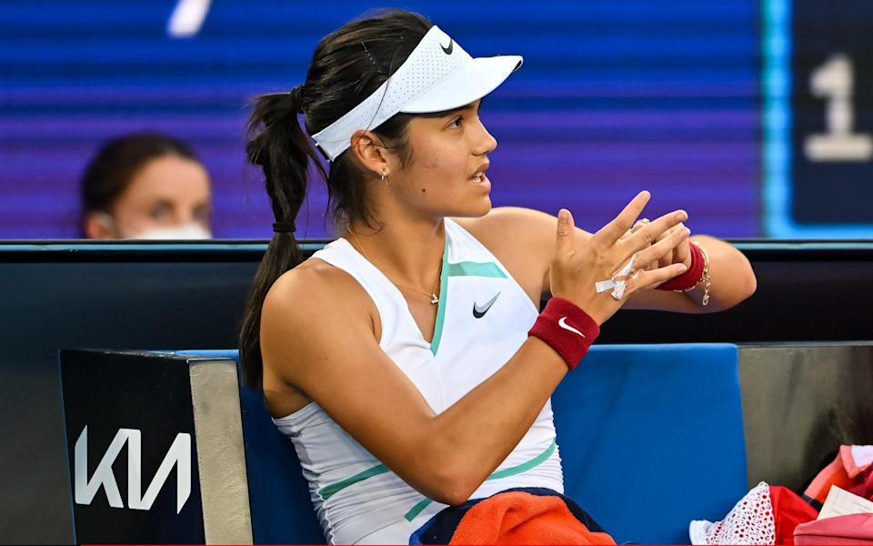 Emma Raducanu of Great Britain examines her injured hand during her match against Danka Kovinic of Montenegro during day four of the 2022 Australian Open at Melbourne Park on January 20, 2022 in Melbourne, Australia - GETTY IMAGES