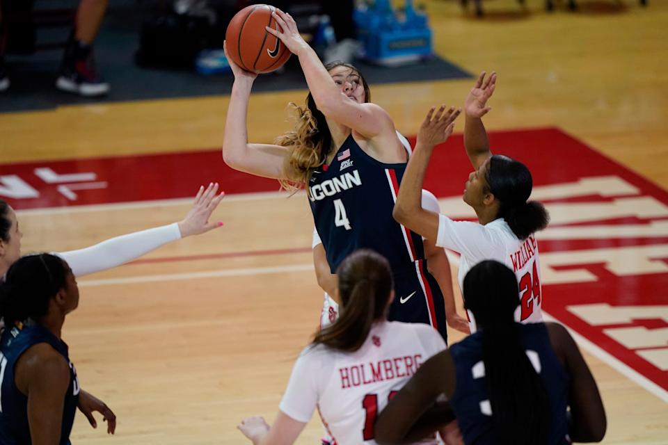 FILE - Connecticut guard Saylor Poffenbarger (4) is defended by St. John's guard Danaijah Williams (24) and forward Cecilia Holmberg (11) during the fourth quarter of an NCAA college basketball game in New York, in this Wednesday, Feb. 17, 2021, file photo. (AP Photo/Kathy Willens, File)