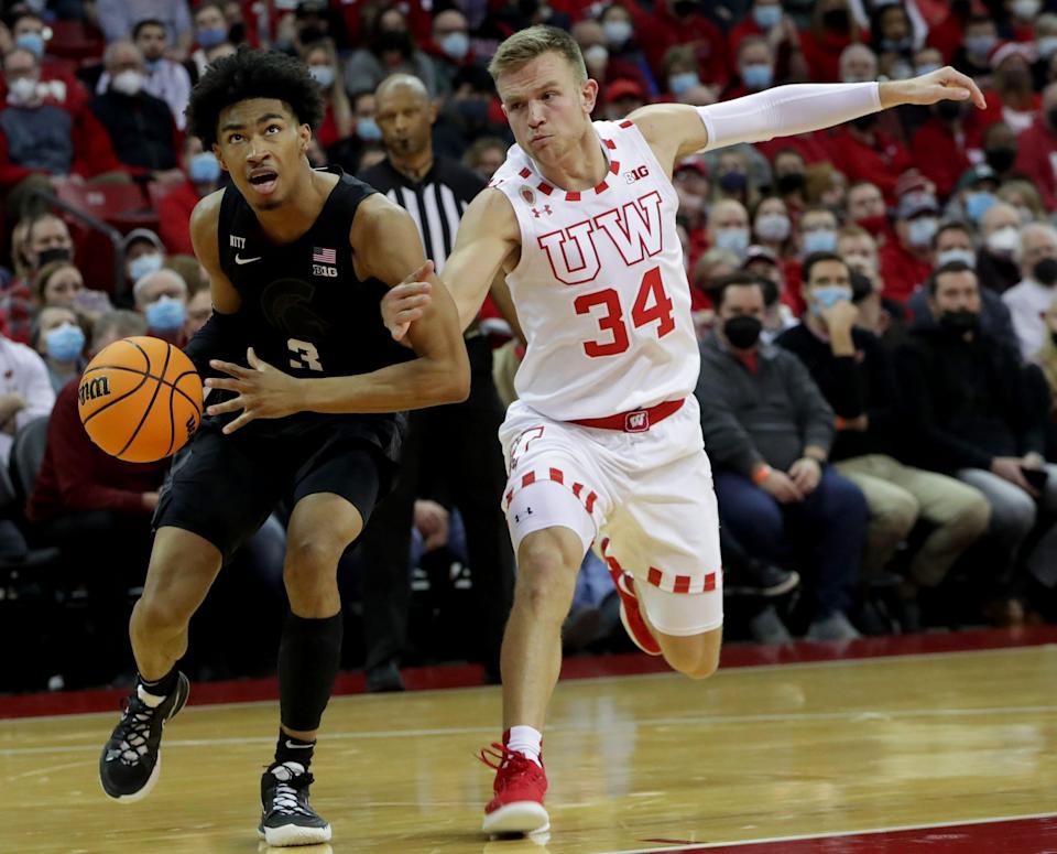 Wisconsin guard Brad Davison fouls Michigan State guard Jaden Akins during the first half Friday.