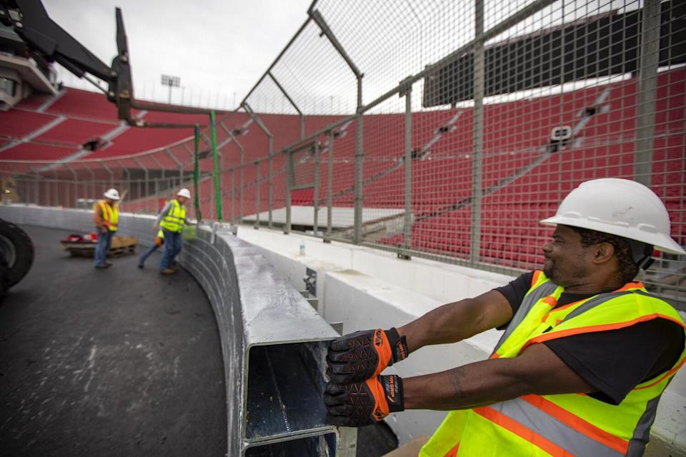 Willie Hairston installs a section of the SAFER barrier around the race track at the Coliseum.
