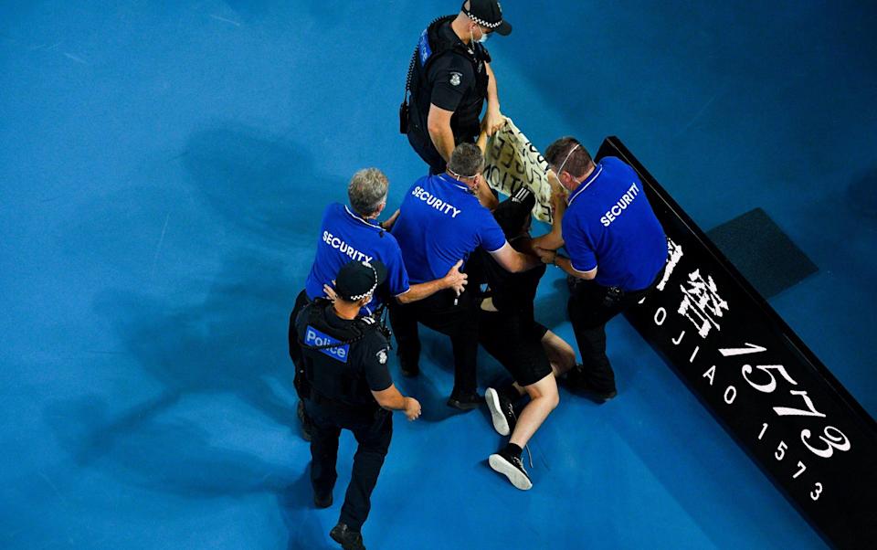 Security remove a protester after invading the court during the men's singles final between Rafael Nadal of Spain and Daniil Medvedev of Russia at the Australian Open grand slam tennis tournament at Melbourne Park in Melbourne, Australia - Shutterstock