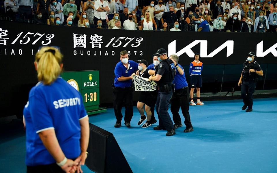 Security remove a protester after invading the court during the men's singles final between Rafael Nadal of Spain and Daniil Medvedev of Russia at the Australian Open grand slam tennis tournament at Melbourne Park in Melbourne, Australia, 30 January 2022. - Shutterstock 