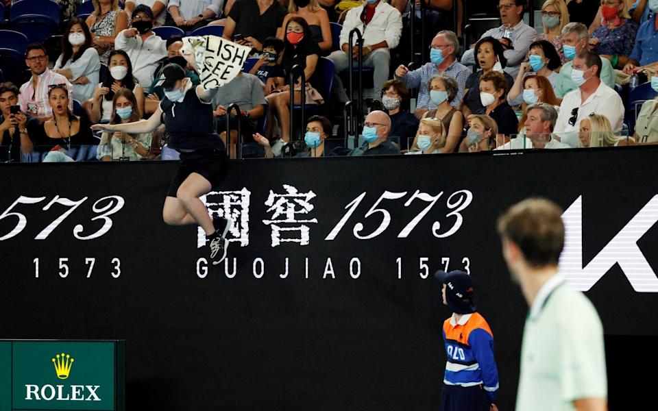 Australian Open - Men's Singles Final - Melbourne Park, Melbourne, Australia - January 30, 2022 A protestor jumps on to the court during the final between Spain's Rafael Nadal and Russia's Daniil Medvedev