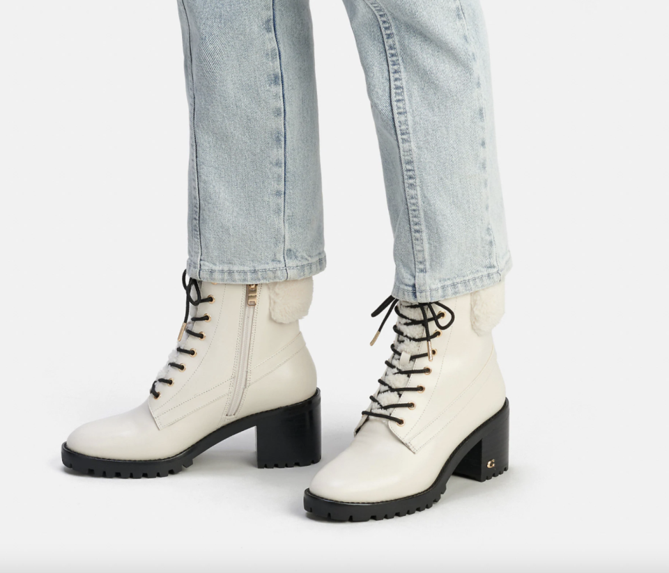 woman wearing white leather boots Jill Boot (Photo via Coach Outlet)