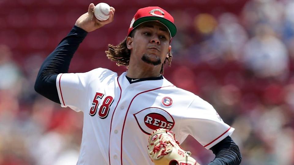 Luis Castillo fires pitch to plate in white Reds jersey