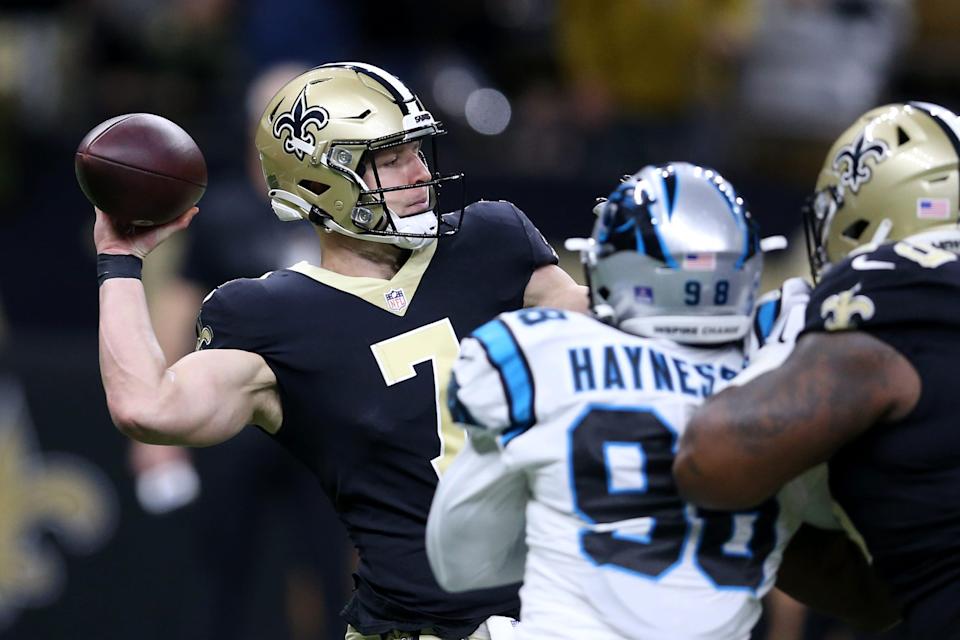 New Orleans Saints quarterback Taysom Hill throws under pressure from Carolina Panthers defensive end Marquis Haynes.