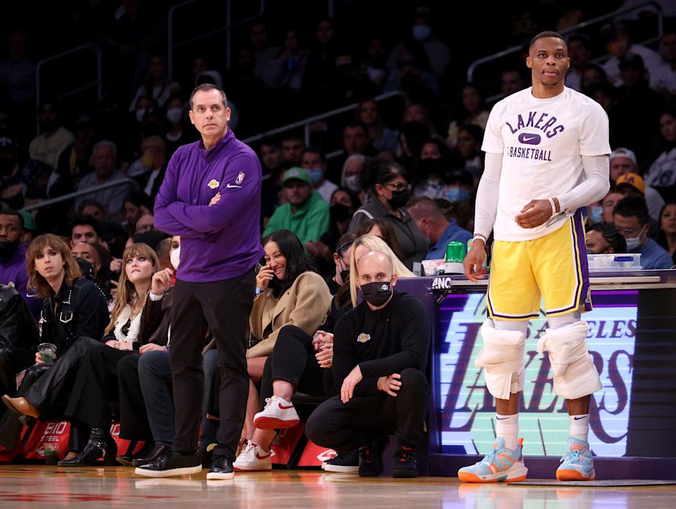 Los Angeles Lakers guard Russell Westbrook and head coach Frank Vogel watch play from the sideline during a game.