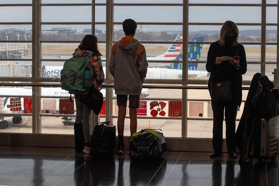 Travelers watch planes on the tarmac at Ronald Reagan International Airport in Washington, DC on Dec. 27, 2021.