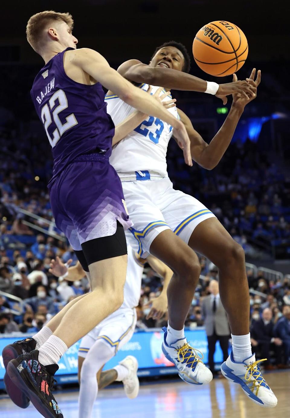 Washington's Cole Bajema, left, fouls UCLA's Peyton Watson during the first half Saturday.