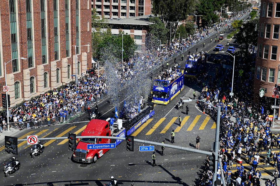 Buses carrying Los Angeles Rams players and coaches drive past fans during the team's victory parade in Los Angeles, Wednesday, Feb. 16, 2022, following their win Sunday over the Cincinnati Bengals in the NFL Super Bowl 56 football game.