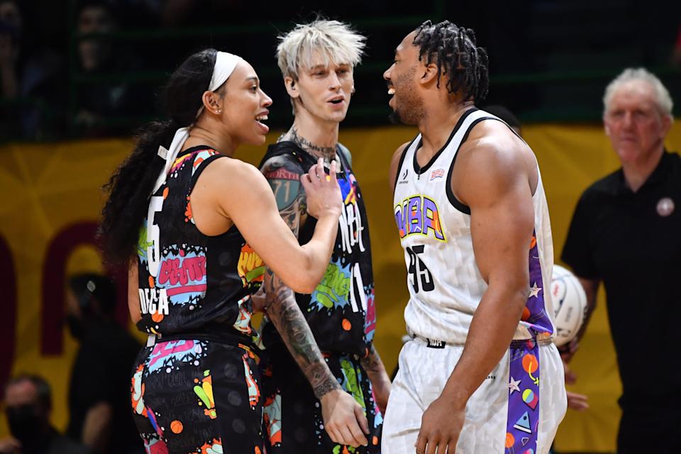 Team Walton’s Dearica Hamby of the Las Vegas Aces and musician Machine Gun Kelly trash talk with Team Nique player Myles Garrett of the Cleveland Browns during the first half of the NBA All-Star Celebrity Game, Feb. 18, 2022, in Cleveland.