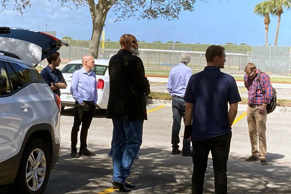 MLB Players Association executive director Tony Clark, left foreground, and chief negotiator Bruce Meyer, second from left, arrive at Roger Dean Stadium in Jupiter, Fla., on Monday for talks with MLB representatives.