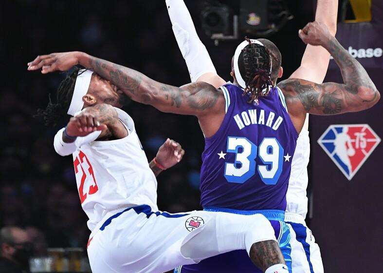 LOS ANGELES-CA-FEBRUARY 25, 2022: Los Angeles Clippers' Robert Covington, left, connects with Los Angeles Lakers' Dwight Howard at Crypto.com Arena in downtown Los Angeles on Friday, February 25, 2022. (Christina House / Los Angeles Times)