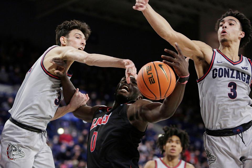 Gonzaga center Chet Holmgren, left, Gonzaga guard Andrew Nembhard, right, and Loyola Marymount guard Eli Scott, center, go after a rebound during the first half of an NCAA college basketball game, Thursday, Jan. 27, 2022, in Spokane, Wash. (AP Photo/Young Kwak)