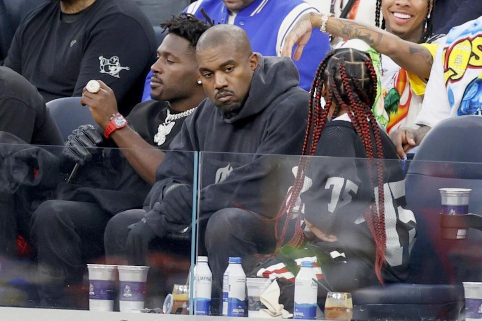 Three people seated at a football game.