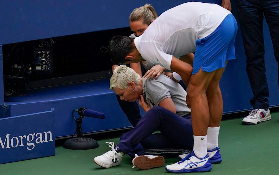 Novak Djokovic checks on the line official he hit at the 2020 US Open - AP