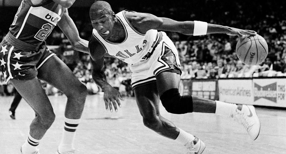 Chicago Bulls' Michael Jordan drives past Washington Bullets' Dudley Bradley during NBA action in Chicago, Oct. 26, 1984. It was Jordan's debut in the regular NBA season. (AP Photo/Fred Jewell)