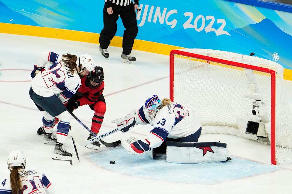 U.S. goalie Alex Cavallini covers the puck in front teammate Kelly Pannek (12) and Canada forward Melodie Daoust during the first period of the gold medal game at the 2022 Beijing Olympics.