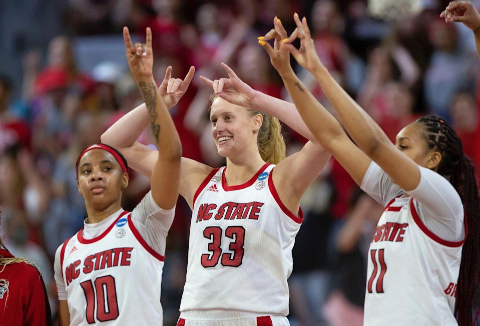 Elissa Cunane and her NC State Wolfpack teammates Aziaha James (left) and Jakia Brown-Turner gesture to the crowd.