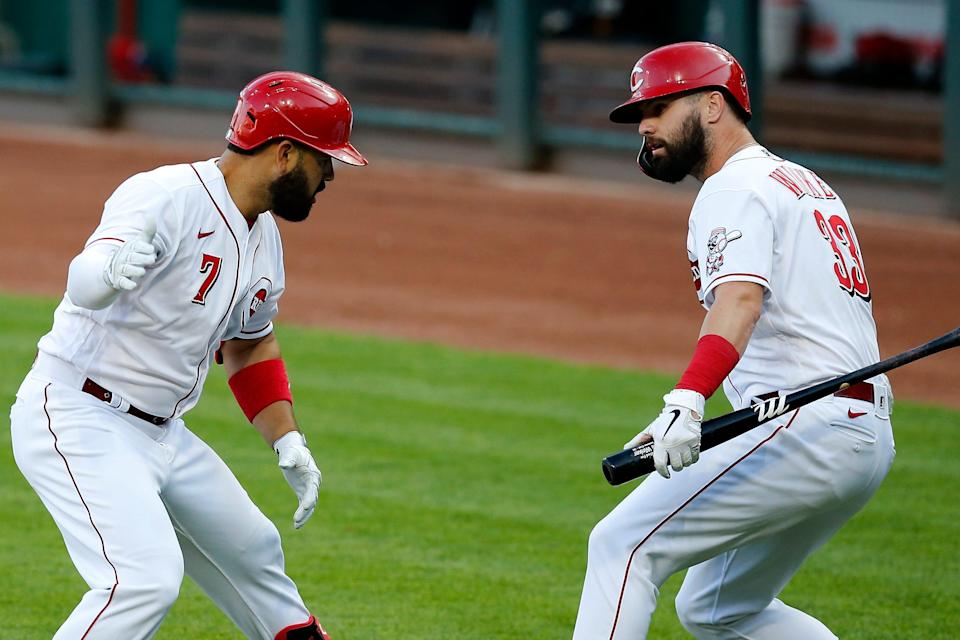 Cincinnati Reds third baseman Eugenio Suarez (7) and designated hitter Jesse Winker (33) celebrate a solo home run by Suarez in the fourth inning of the MLB interleague game between the Cincinnati Reds and the Cleveland Indians at Great American Ball Park in downtown Cincinnati on Tuesday, Aug. 4, 2020. The Reds led 2-0 after five innings. 