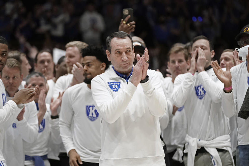 Surrounded by former players, Duke coach Mike Krzyzewski applauds while being recognized prior to the team's NCAA college basketball game against North Carolina in Durham, N.C., Saturday, March 5, 2022. The matchup is Krzyzewski's final game at Cameron Indoor Stadium. (AP Photo/Gerry Broome)