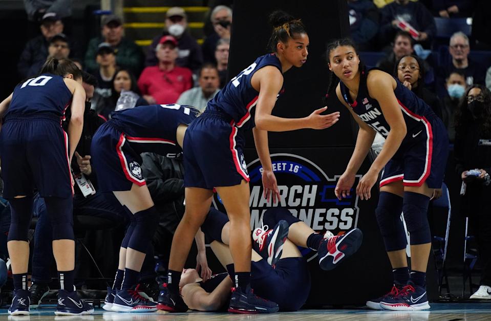 UConn players surround Juhasz after she injured her wrist.