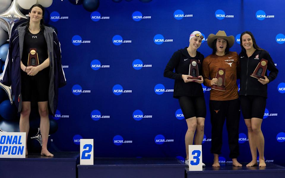 Emma Weyant, Erica Sullivan and Brooke Forde huddle around the third place position on the podium after Lia Thomas' win - Justin Casterline/Getty Images