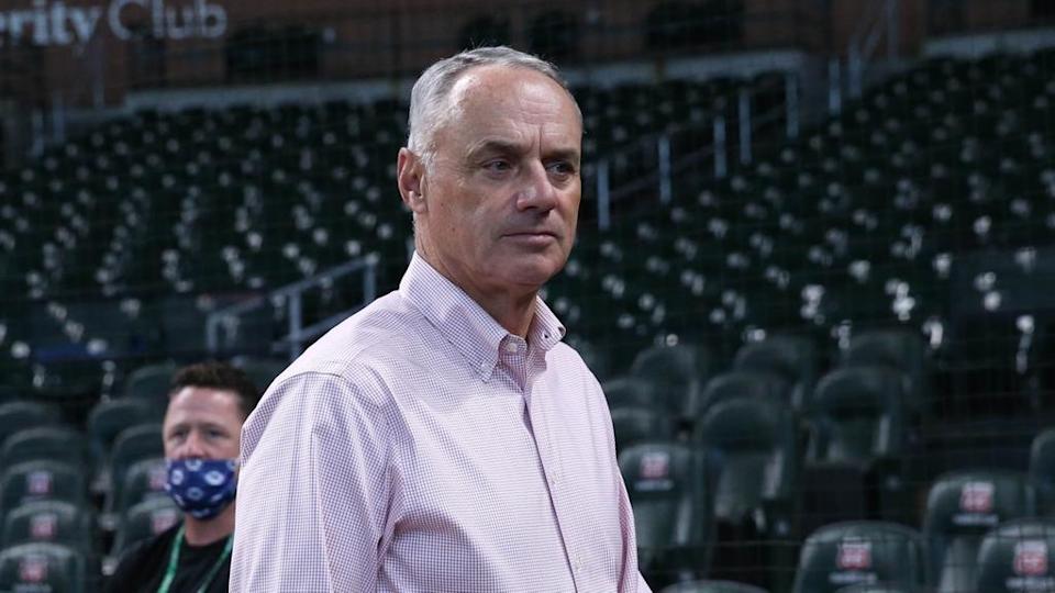 Rob Manfred on field in pink shirt looking perturbed