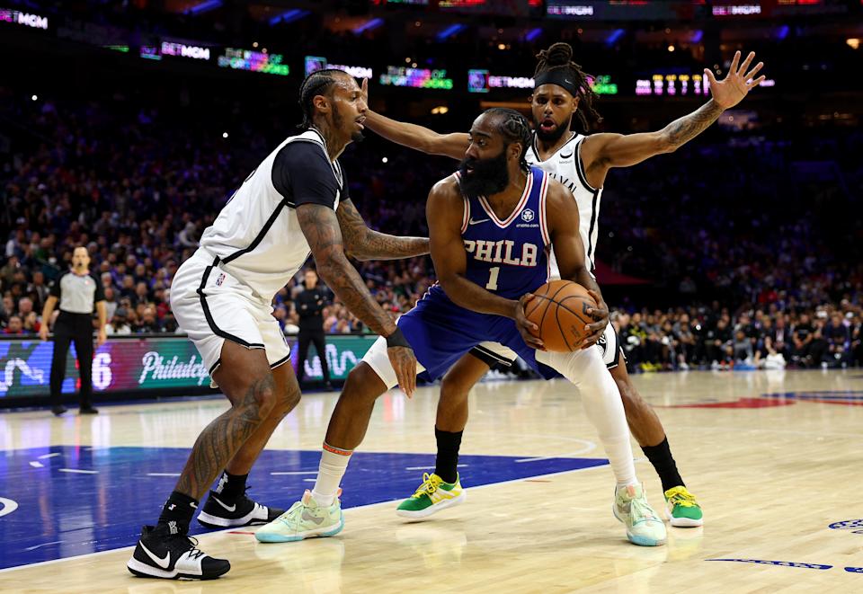 PHILADELPHIA, PENNSYLVANIA - MARCH 10: James Harden #1 of the Philadelphia 76ers is surrounded by James Johnson #16 and Patty Mills #8 of the Brooklyn Nets in the first half at Wells Fargo Center on March 10, 2022 in Philadelphia, Pennsylvania. NOTE TO USER: User expressly acknowledges and agrees that, by downloading and or using this photograph, User is consenting to the terms and conditions of the Getty Images License Agreement. (Photo by Elsa/Getty Images)