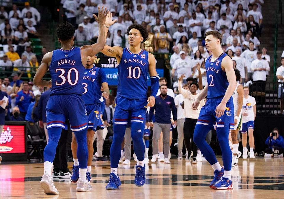 Kansas guard Ochai Agbaji (30) and forward Jalen Wilson (10) high five after forcing Baylor to call a timeout, as guard Christian Braun (2) looks on during an NCAA college basketball game Saturday, Feb. 26, 2022, in Waco, Texas. Baylor won 80-70.