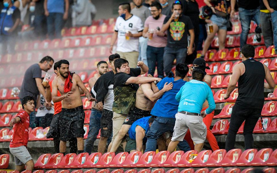 Fans clash during a Mexican soccer league match between the host Queretaro and Atlas from Guadalajara, at the Corregidora stadium, in Queretaro, Mexico, Saturday, March 5, 2022 - AP