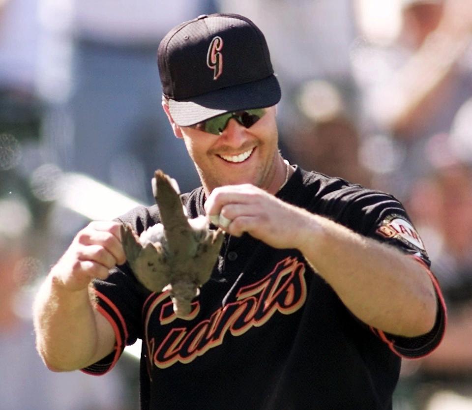 San Francisco Giants' Jeff Kent holds up a bird that was killed when it flew in the path of a pitch thrown by Arizona Diamondbacks ace Randy Johnson in the seventh inning Saturday, March 24, 2001 at Tucson Electric Park in Tucson, Ariz.. The Diamondbacks beat the Giants 10-6 in exhibition play.