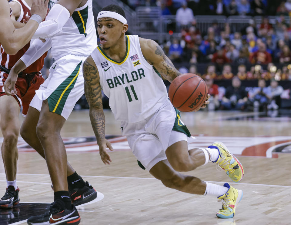 KANSAS CITY, MO - MARCH 10: James Akinjo #11 of the Baylor Bears drives to the basket during the game against the Oklahoma Sooners at T-Mobile Center on March 10, 2022 in Kansas City, Missouri. (Photo by Michael Hickey/Getty Images)