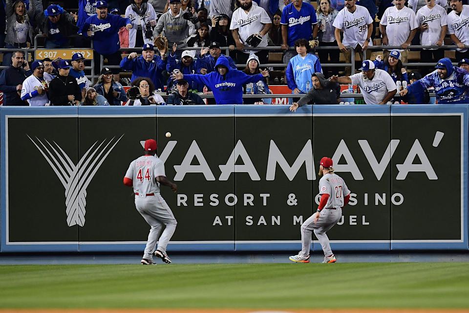 Apr 14, 2022; Los Angeles, California, USA; Cincinnati Reds left fielder Aristides Aquino (44) and center fielder Jake Fraley (27) play for the ground rule double hit by Los Angeles Dodgers first baseman Freddie Freeman (5) during the eighth inning at Dodger Stadium. Mandatory Credit: Gary A. Vasquez-USA TODAY Sports