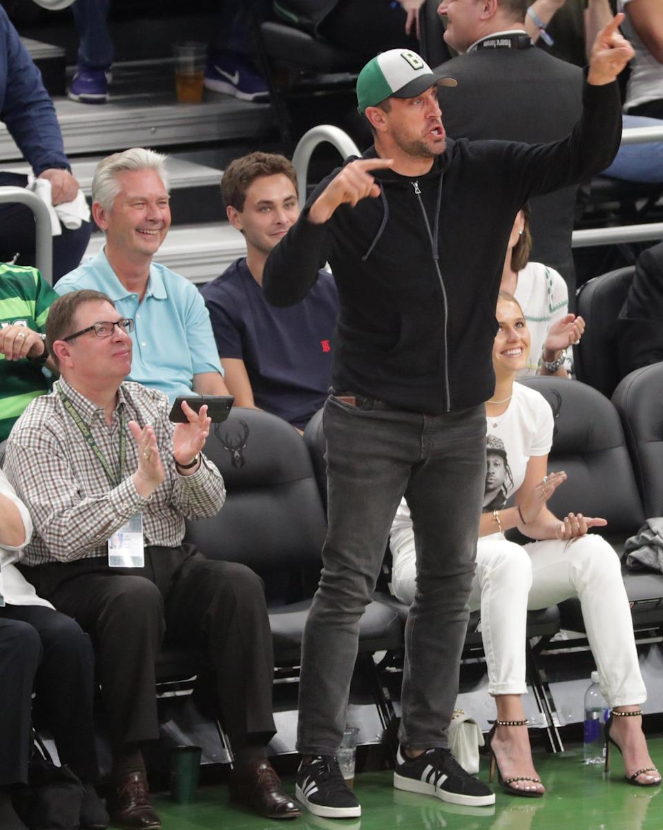 In his last public appearance at a Bucks game, Aaron Rodgers cheers from his courtside seats when teammate David Bakhtiari was chugging beer during the first half of Game 5 of the Bucks' Eastern Conference finals series in 2019.