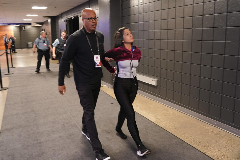 An animal cruelty activist is taken away in handcuffs after she attempted to protest during the Minnesota Timberwolves and Memphis Grizzlies Game 4 of an NBA basketball first-round playoff series Saturday, April 23, 2022, in Minneapolis. (AP Photo/Craig Lassig)