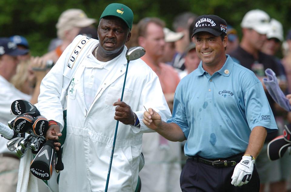 Caddie Buck Moore, of Augusta, takes the driver from Olin Browne as they leave the 14th tee during Monday's practice round of the 2006 Masters.