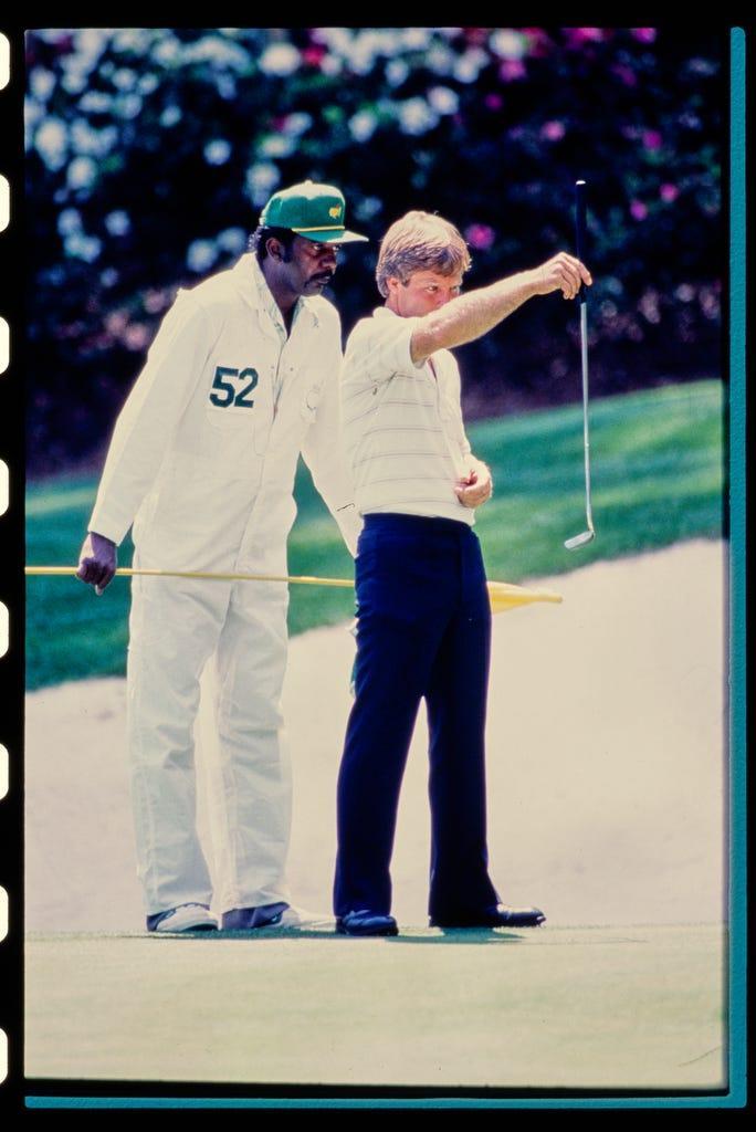 Caddie Carl Jackson helps Ben Crenshaw line up a putt in the 1984 Masters. Crenshaw's decision in 1983 to keep Jackson as his caddie paid off in 1984 when Crenshaw won his first green jacket.