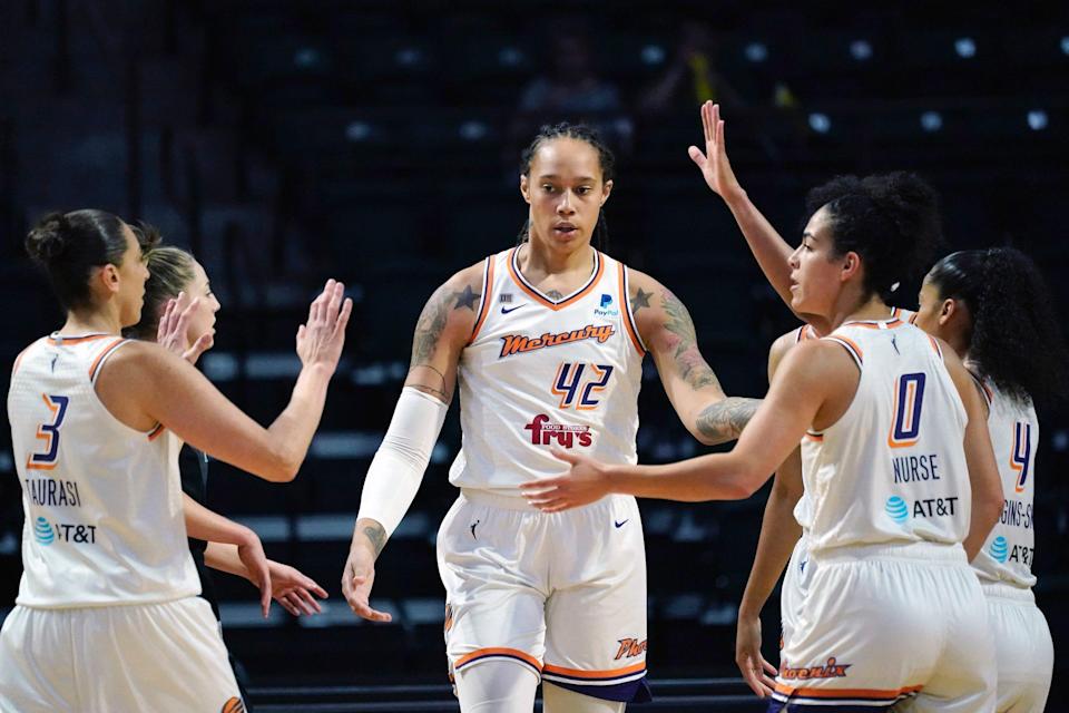 Brittney Griner high fives her Phoenix Mercury teammates.