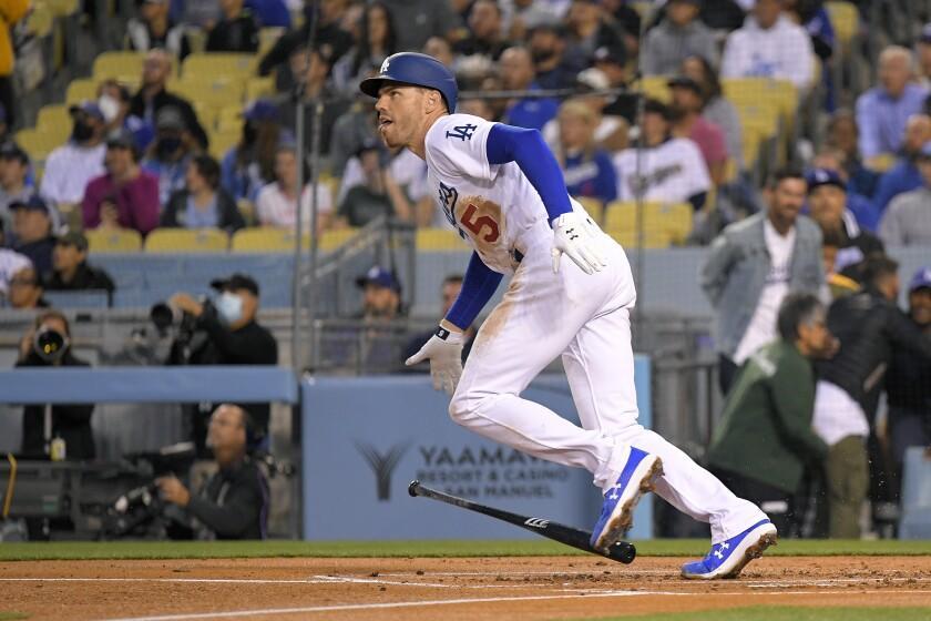 Los Angeles Dodgers' Freddie Freeman drops hit bat as he hits a solo home run.