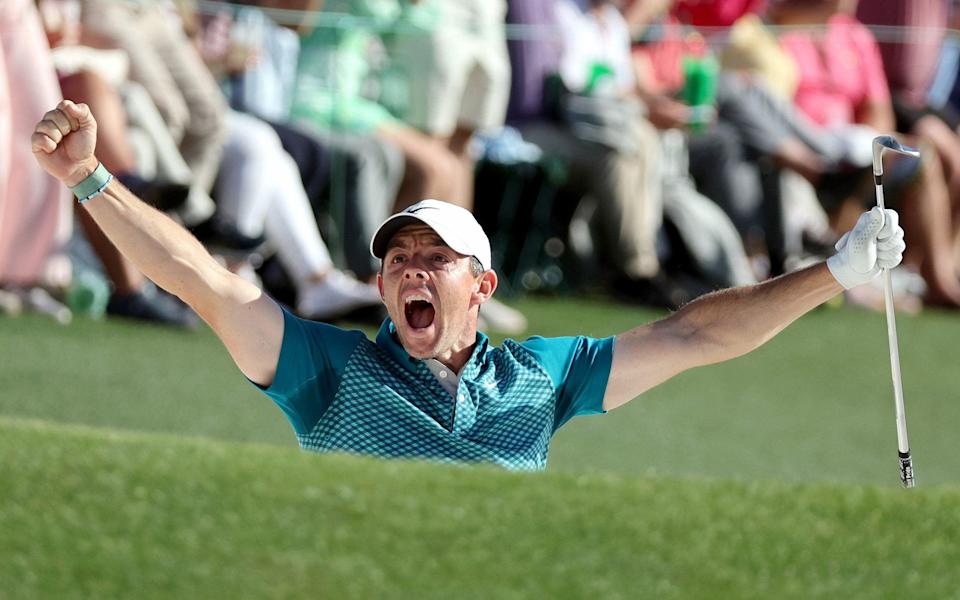 Rory McIlroy reacts after chipping in for birdie from the bunker on the 18th green - GETTY IMAGES