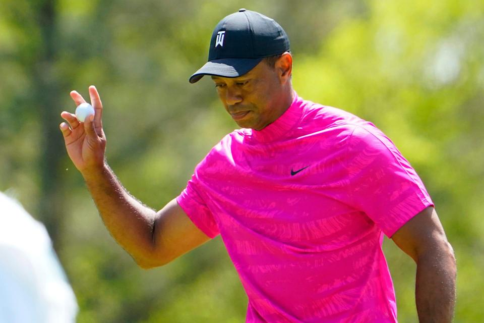 Tiger Woods waves to the crowd after sinking a putt on No. 6.