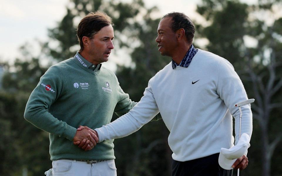 Tiger Woods shakes hands with Kevin Kisner on the 18th green after their third round - REUTERS/Brian Snyder