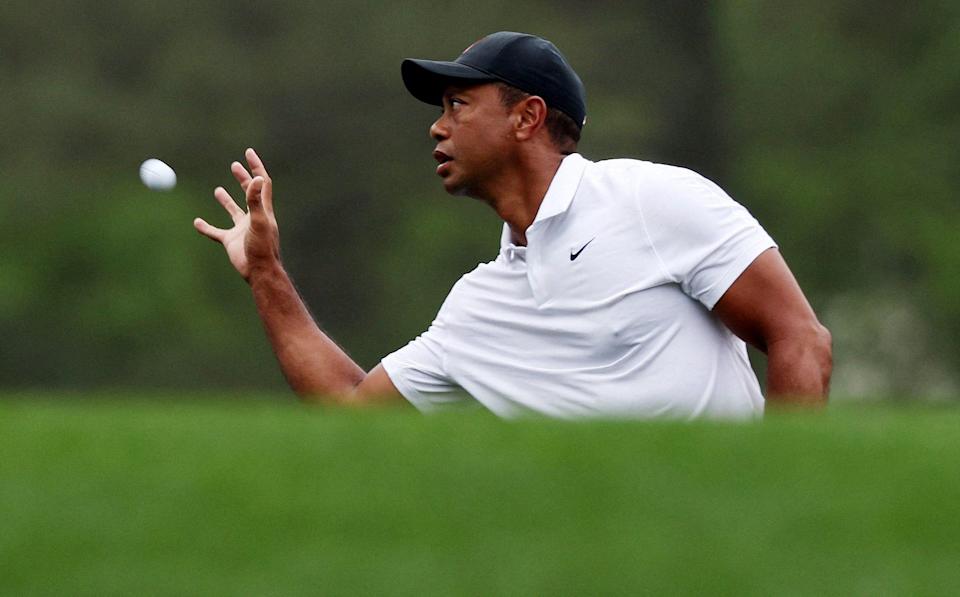 The Masters - Augusta National Golf Club - Augusta, Georgia, U.S. - April 6, 2022 Tiger Woods of the U.S. catches a golf ball on the 11th green during a practice round - REUTERS