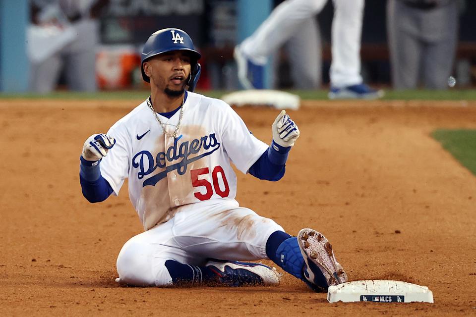 LOS ANGELES, CALIFORNIA - OCTOBER 19: Mookie Betts #50 of the Los Angeles Dodgers slides into second base for an RBI double scoring the go-ahead run during the 8th inning of Game 3 of the National League Championship Series against the Atlanta Braves at Dodger Stadium on October 19, 2021 in Los Angeles, California. (Photo by Ronald Martinez/Getty Images)