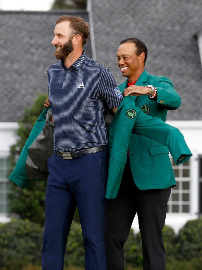 Tiger Woods puts the green jacket on Dustin Johnson at the 2020 Masters.