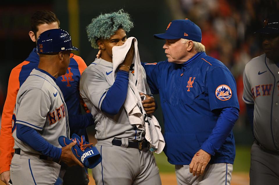 New York Mets shortstop Francisco Lindor covers his face after being hit by a pitch while manager Buck Showalter walks with him during the fifth inning against the Washington Nationals at Nationals Park.