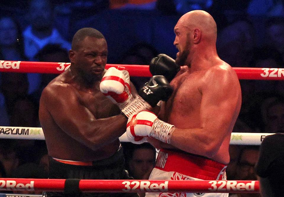 Britain's Tyson Fury (R) lands a punch to knockout Britain's Dillian Whyte in the sixth round and win their WBC heavyweight title fight at Wembley Stadium in west London, on April 23, 2022. (Photo by Adrian DENNIS / AFP) (Photo by ADRIAN DENNIS/AFP via Getty Images)