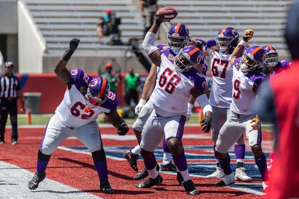 Pittsburgh Maulers linemen celebrate a touchdown against the Philadelphia Stars in front of mostly empty stands.